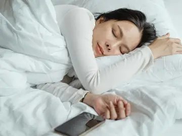 Joven durmiendo con su teléfono móvil al lado Joven durmiendo con su teléfono móvil al lado