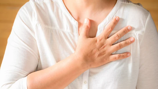 Una mujer con la mano en el pecho. El dolor en el pecho es el síntoma más común del infarto en hombres y en mujeres Una mujer con la mano en el pecho. El dolor en el pecho es el síntoma más común del infarto en hombres y en mujeres
