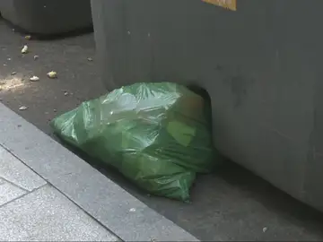 Una bolsa de basura fuera del contenedor