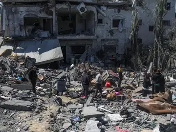 Ciudadanos alestinos rescatan algunas pertenencias y buscan personas desaparecidas entre los escombros de una casa destruida tras un ataque aéreo israelí en Deir Al Balah, Gaza, el 13 de marzo de 2024