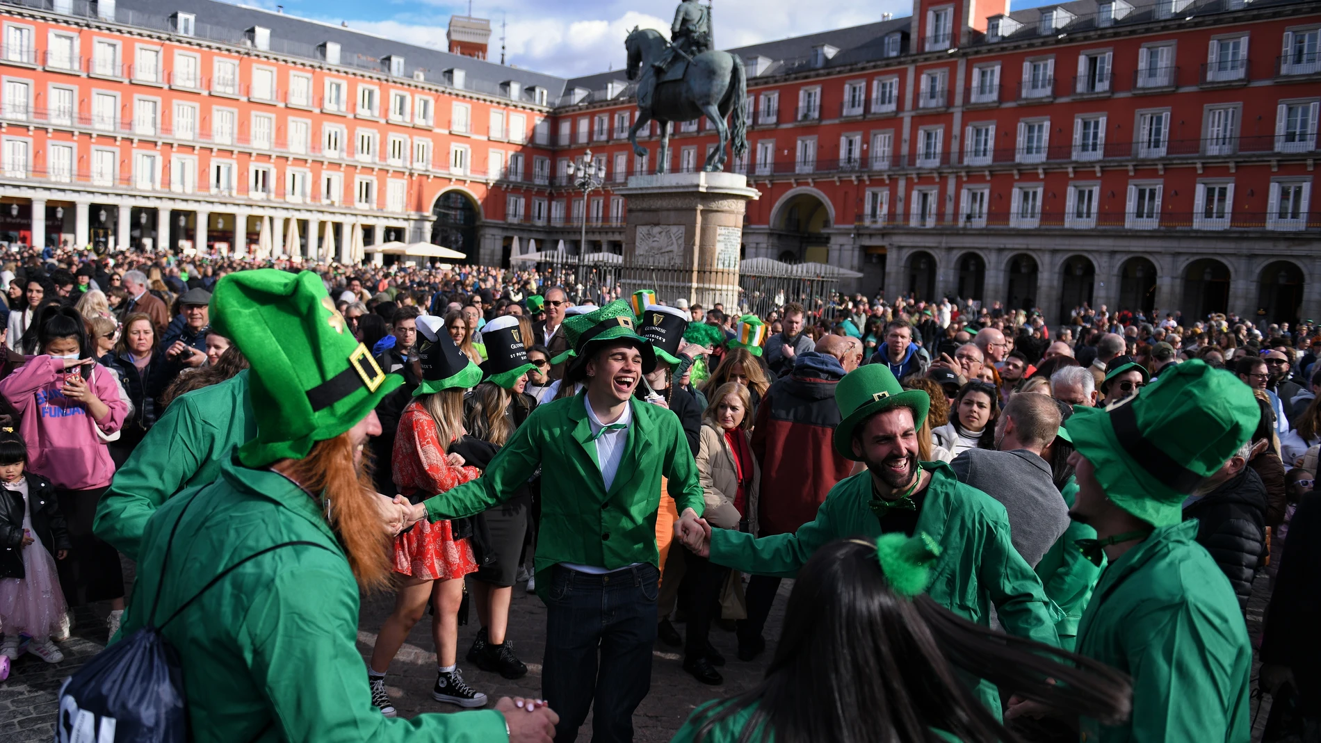 Asistentes vestidos con ropas típicas participan en el desfile que se celebra en honor a San Patricio, patrón de Irlanda, en la Plaza Mayor, a 18 de marzo de 2023, en Madrid (España). 