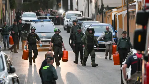 Especialistas del Tédax (Técnico Especialista en Desactivación de Artefactos Explosivos) y miembros del cuerpo de bomberos retiran las bombonas de butano con las que se había atrincherado un vecino de Las Gabias, Granada