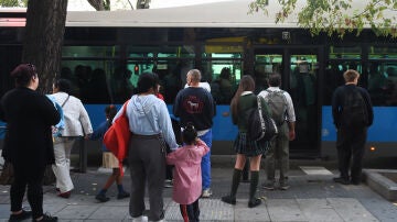 Varias personas delante de un bus de la EMT en el barrio de Puente de Vallecas, a 27 de septiembre de 2023.