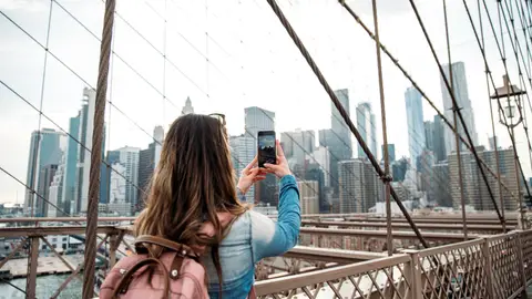 Chica joven usando su móvil en Manhattan Chica joven usando su móvil en Manhattan