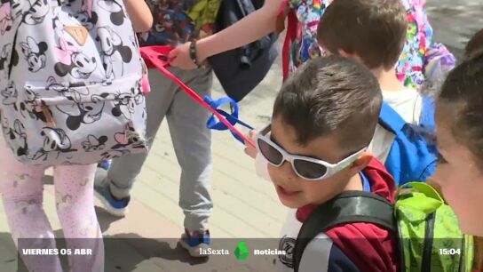 Ni&ntilde;os caminando agarrados a una cuerda para llegar al comedor