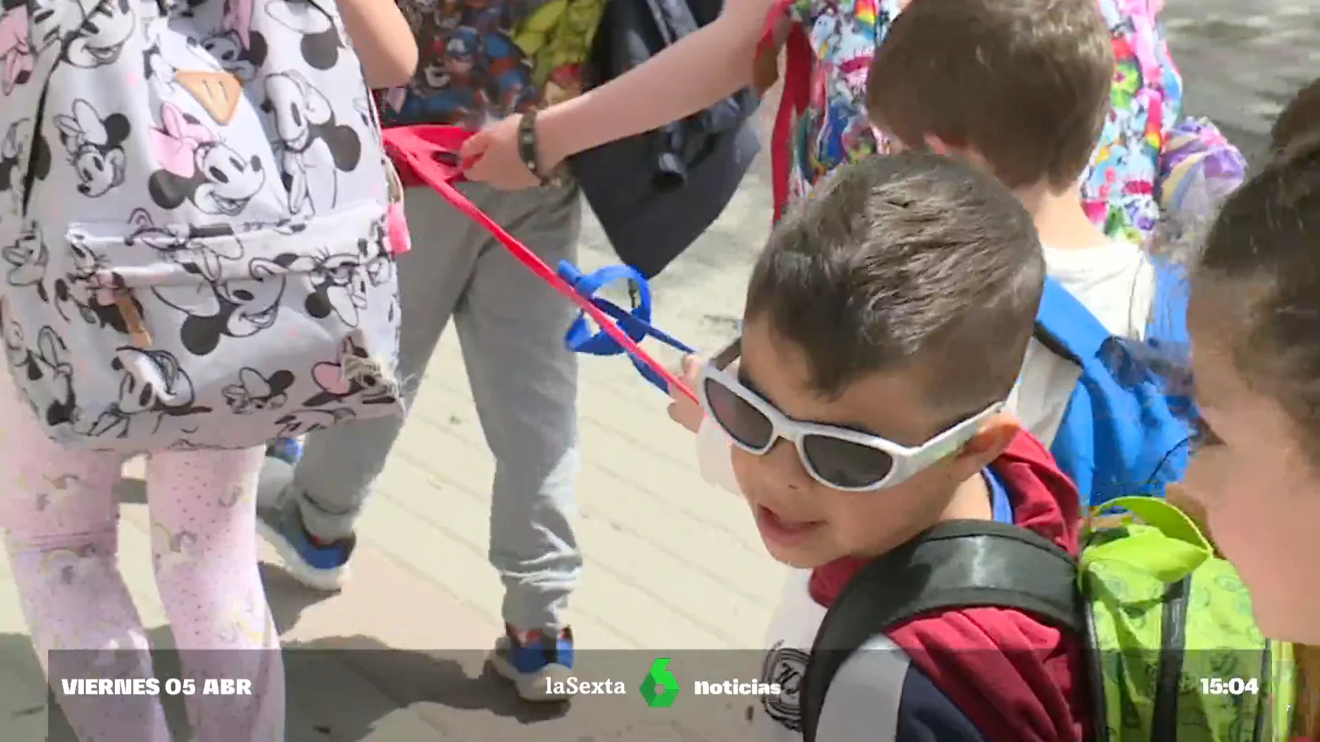 Niños caminando agarrados a una cuerda para llegar al comedor