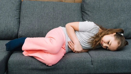 Una niña con dolor de tripa o dolor abdominal. Una niña con dolor de tripa o dolor abdominal.