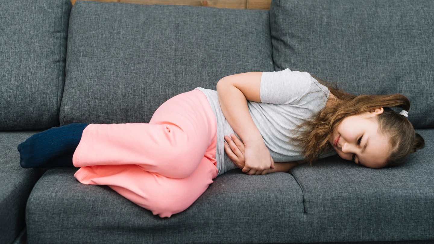 Una niña con dolor de tripa o dolor abdominal. Una niña con dolor de tripa o dolor abdominal.