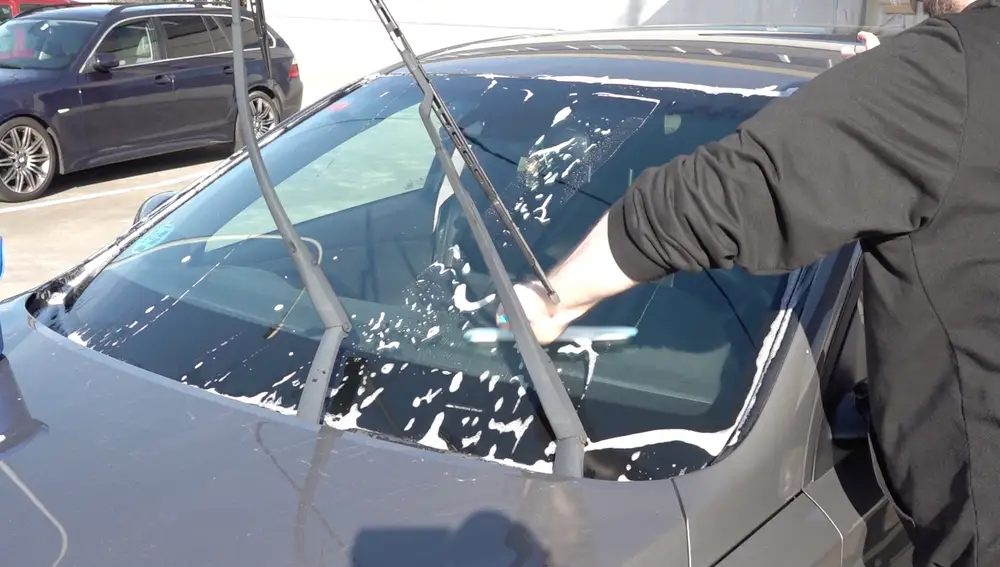 Hombre lavando el parabrisas Hombre lavando el parabrisas