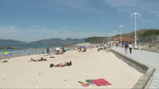 Gente disfruta de un d&iacute;a soleado en una playa de Vigo