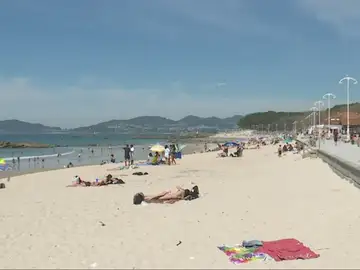 Gente disfruta de un día soleado en una playa de Vigo