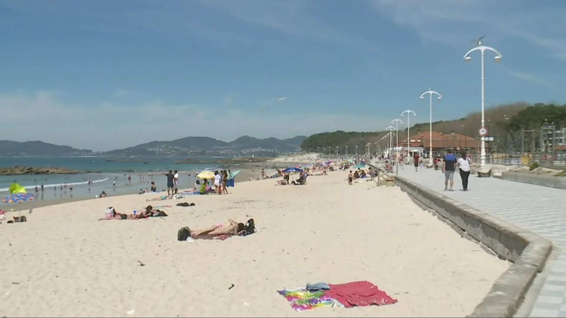 Gente disfruta de un día soleado en una playa de Vigo