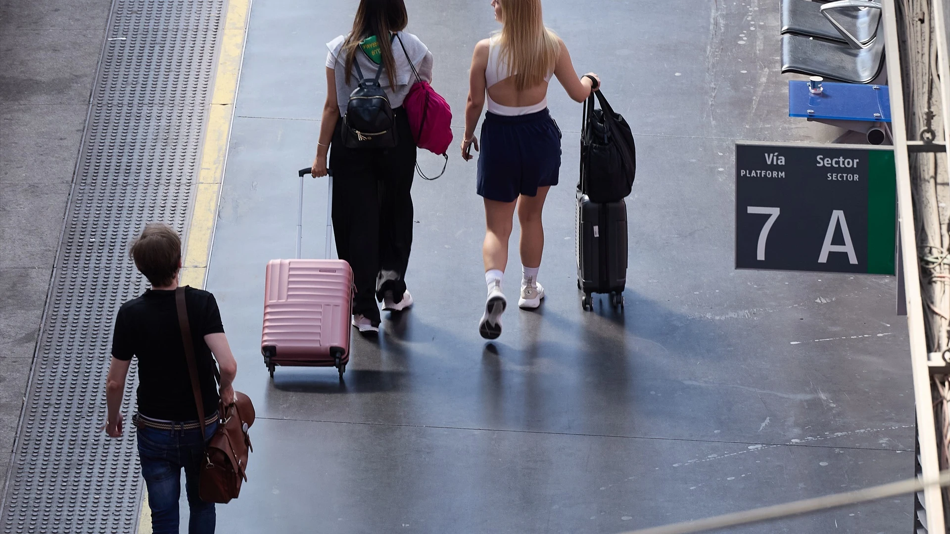 Jóvenes con sus maletas en una estación de tren.