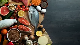Una cesta de alimentos con pescados, carnes, frutas, verduras...