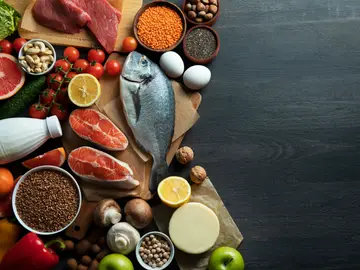 Una cesta de alimentos con pescados, carnes, frutas, verduras...