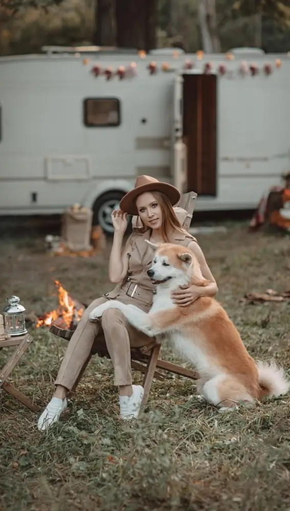 Mujer con perro en un camping de caravanas y autocaravanas