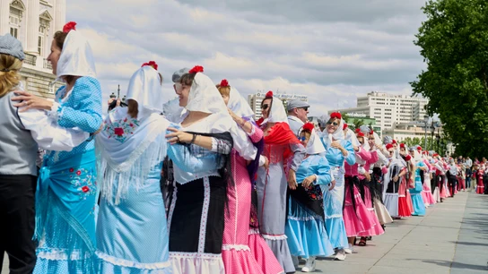 Una fila de chulapas bailando por Madrid en las fiestas de San Isidro Una fila de chulapas bailando por Madrid en las fiestas de San Isidro