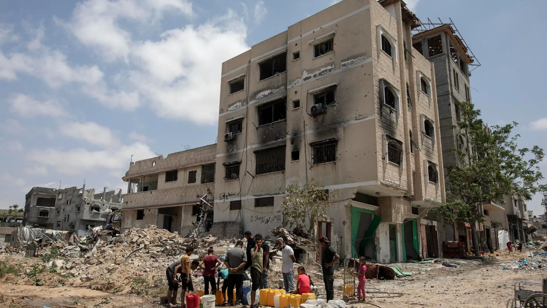 Un grupo de palestinos recoge agua de un pozo subterráneo tras la destrucción de los ataques de Israel sobre Khan Yunis. 