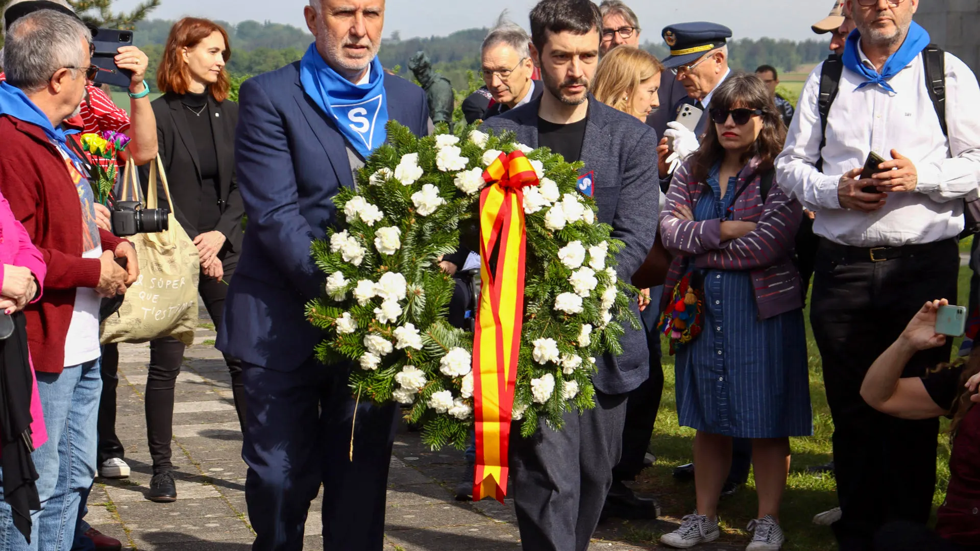 Pablo Bustinduy y Ángel Víctor Torres llevan una corona de flores durante los actos de conmemoración del 79 aniversario de liberación del campo de concentración de Mathausen