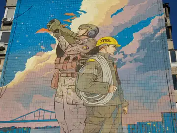 Un mural dedicado a los &#39;Defensores de la luz&#39; en Ucrania, que representa a un soldado ucraniano protegiendo los cielos de las amenazas aéreas y a un trabajador de la energía listo para reparar las redes eléctricas en caso de daños. 