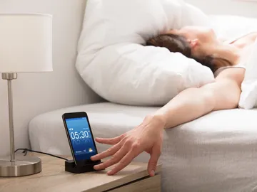 Persona quitando la alarma del móvil Persona quitando la alarma del móvil