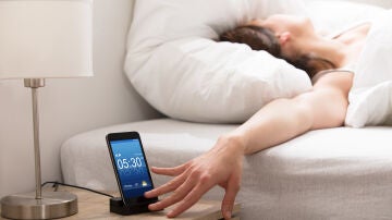 Persona quitando la alarma del móvil