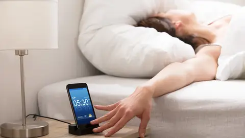 Persona quitando la alarma del móvil Persona quitando la alarma del móvil