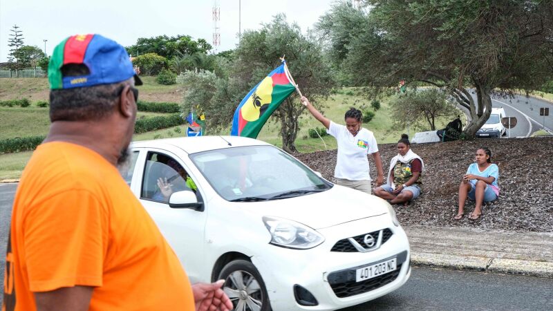 Un manifestante ondea una bandera del Frente de Liberación Nacional de los Kanaks (FLNKS)