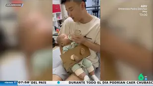 Esposa a su bebé para que no se mueva mientras le da el biberón