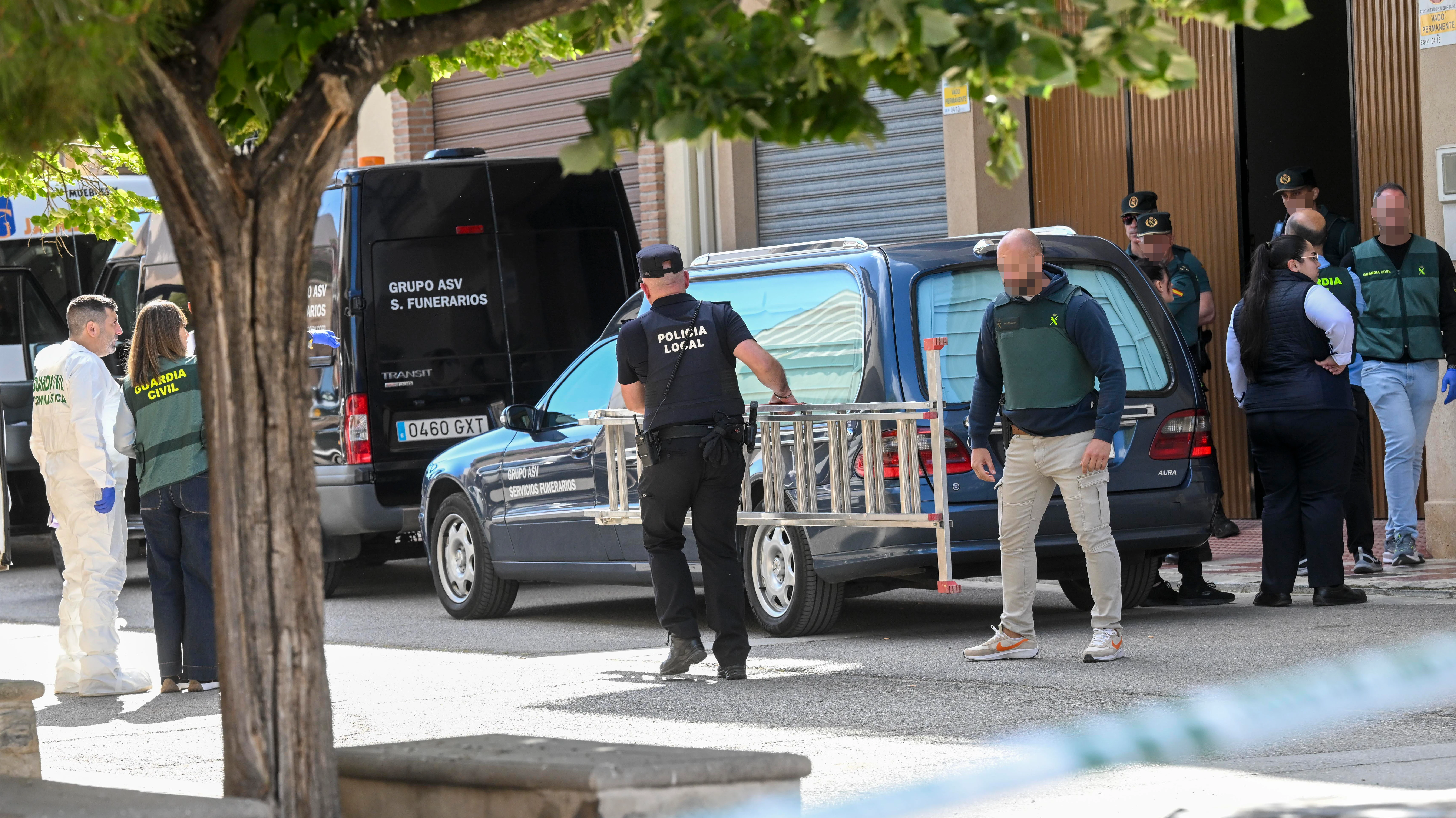 El coche fúnebre espera para salir con los cuerpos del hombre de 72 años junto a sus dos nietos, de 10 y 12 años