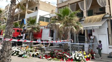 Coronas de flores y velas recuerdan a las víctimas del derrumbe del restaurante 'Medusa Beach Club', en la Playa de Palma