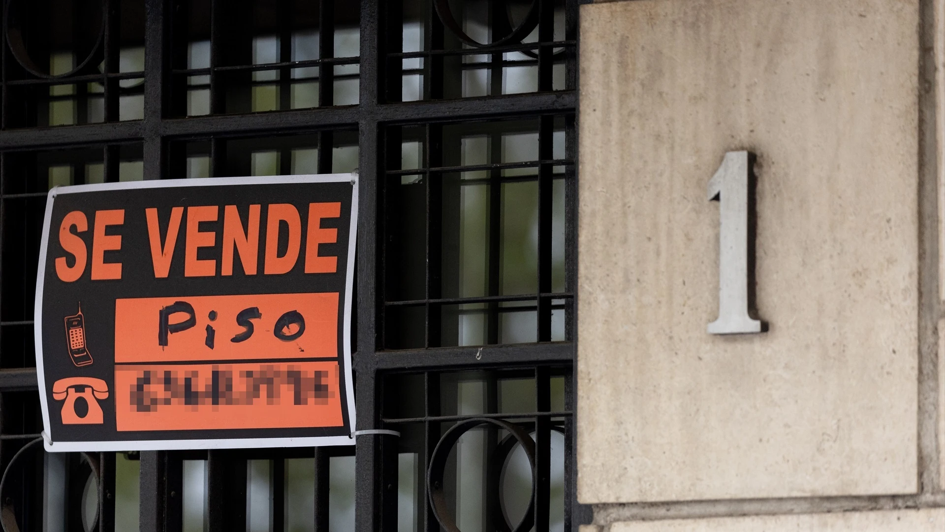 Imagen de un cartel de 'Se vende' conlgado en una vivienda