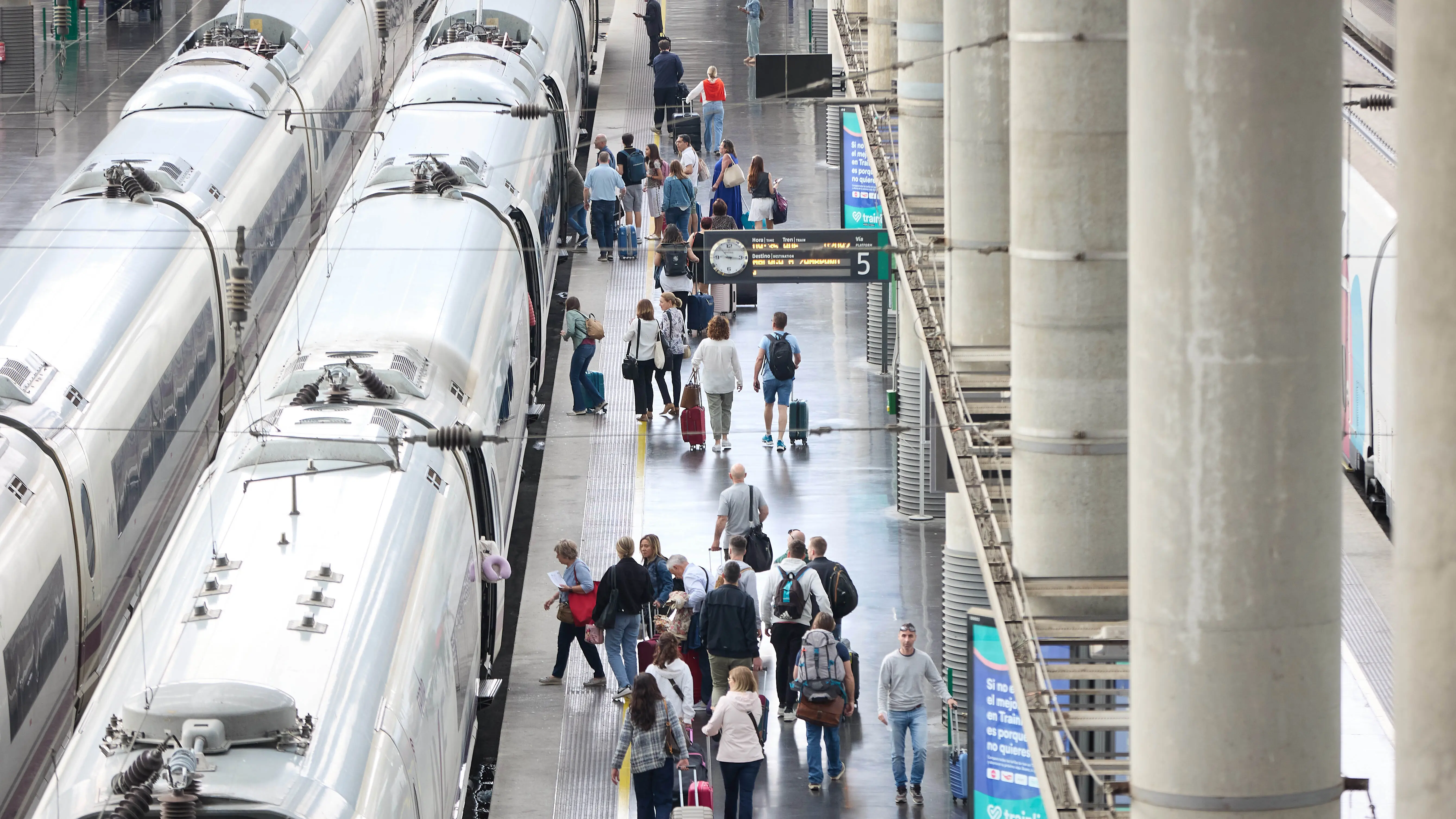 Viajeros con maletas en uno de los andenes de la estación Almudena Grandes-Atocha Cercanías, a 28 de abril de 2023, en Madrid (España).