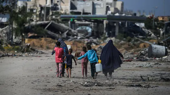 Palestinos desplazados internos caminan junto a edificios destruidos en Khan Younis, al sur de la Franja de Gaza. Palestinos desplazados internos caminan junto a edificios destruidos en Khan Younis, al sur de la Franja de Gaza.