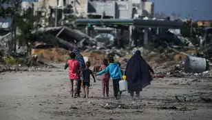 Palestinos desplazados internos caminan junto a edificios destruidos en Khan Younis, al sur de la Franja de Gaza. 