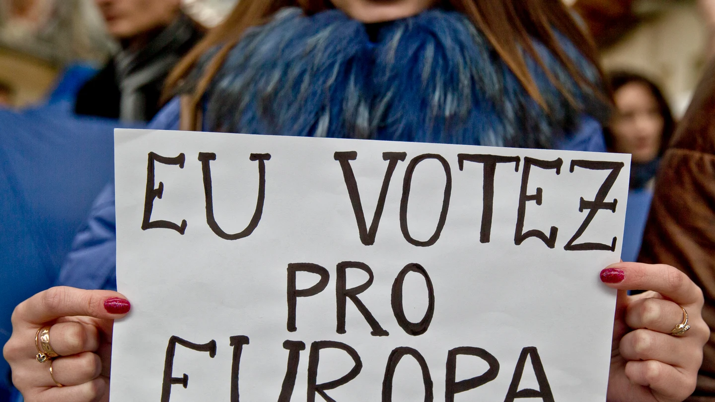 Una joven sostiene un cartel con la frase "yo voto por Europa" en rumano. Una joven sostiene un cartel blanco con la frase "yo voto por Europa" escrita en rumano.