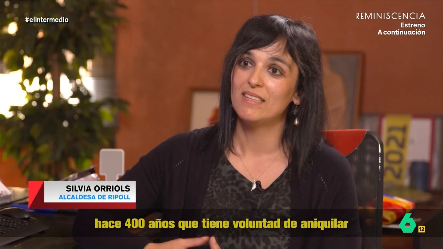 El surrealista discurso de Silvia Orriols: "El Estado español quiere aniquilar la raza catalana con inmigrantes conflictivos" Andrea Ropero entrevista a Silvia Orriols, la alcaldesa de Ripoll que lidera Aliança Catalana. En este vídeo niega ser de extrema derecha, aunque asegura rotunda que es islamófoba, y despliega su argumentario ultranacionalista y antimigración.