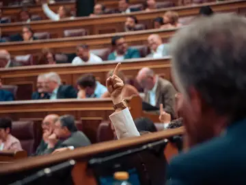 Una diputada levanta un dedo indicando el número de una votación, durante una sesión plenaria, en el Congreso de los Diputados, a 11 de junio de 2024, en Madrid (España).