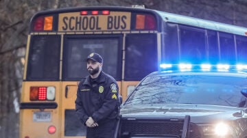 Imagen de archivo de un policía estadounidense junto a un autobús 