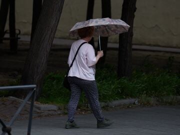 Una mujer utiliza un paraguas para protegerse de la lluvia