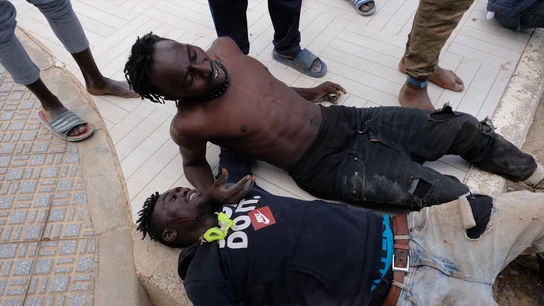 Dos migrantes descansan tras saltar la valla de Melilla, a 24 de junio de 2022, en Melilla (España). Dos migrantes descansan tras saltar la valla de Melilla, a 24 de junio de 2022, en Melilla (España).