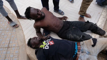 Dos migrantes descansan tras saltar la valla de Melilla, a 24 de junio de 2022, en Melilla (España).