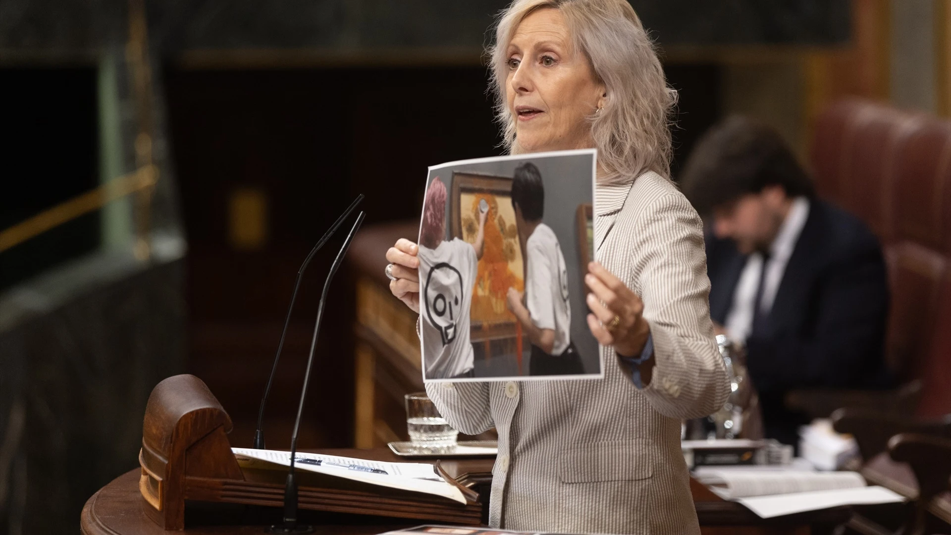 La diputada del PP Marta González muestra una imagen de un acto vandálico durante su intervención durante una sesión plenaria