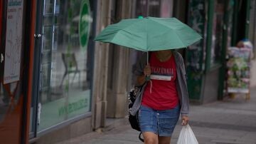 Una mujer se protege de la lluvia con un paraguas, a 8 de junio de 2024, en Madrid (España).