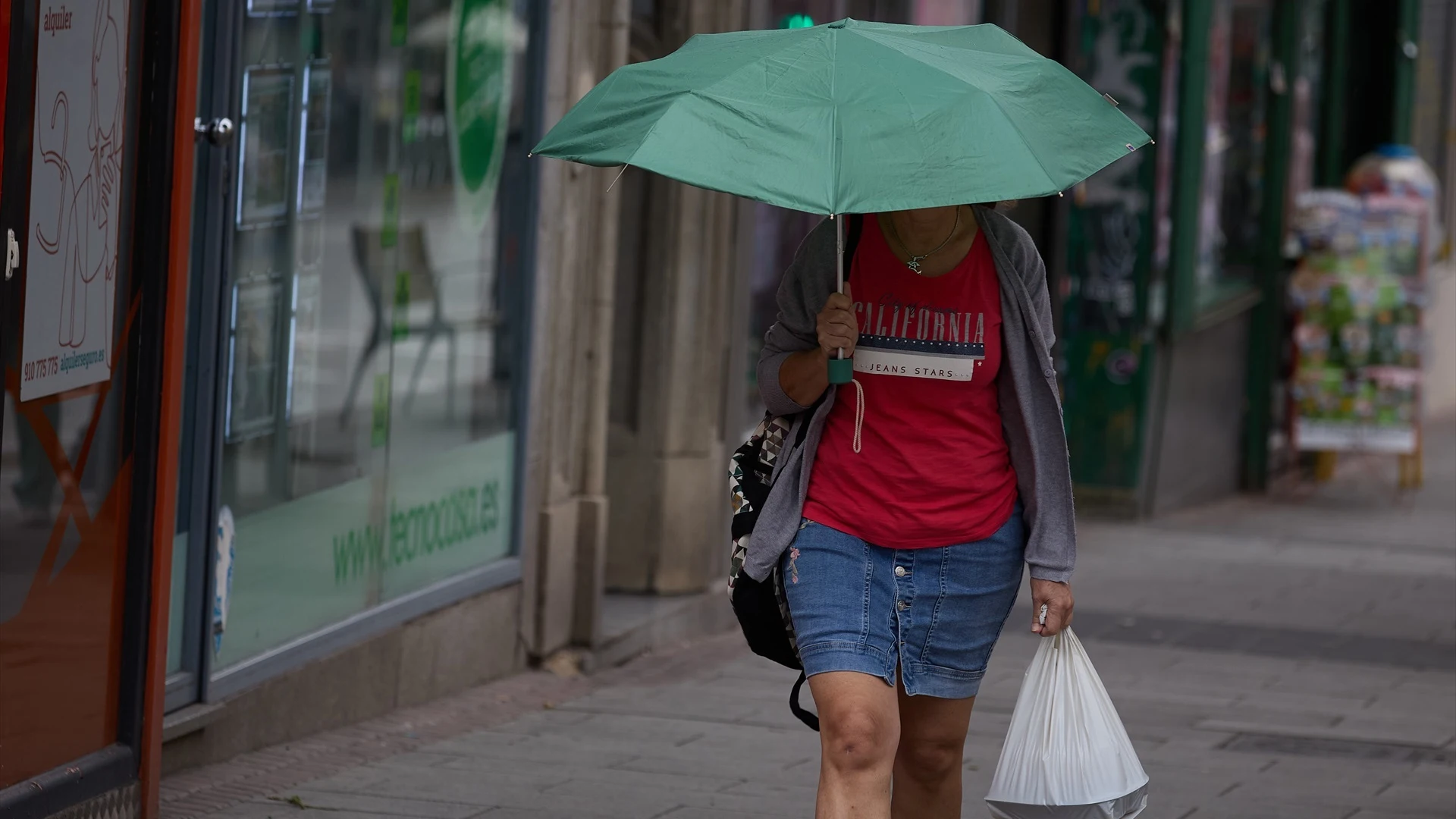 Una mujer se protege de la lluvia con un paraguas, a 8 de junio de 2024, en Madrid (España).