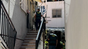 Agentes de la Guardia Civil inspeccionan el exterior de la vivienda en Castell de Ferro (Granada)