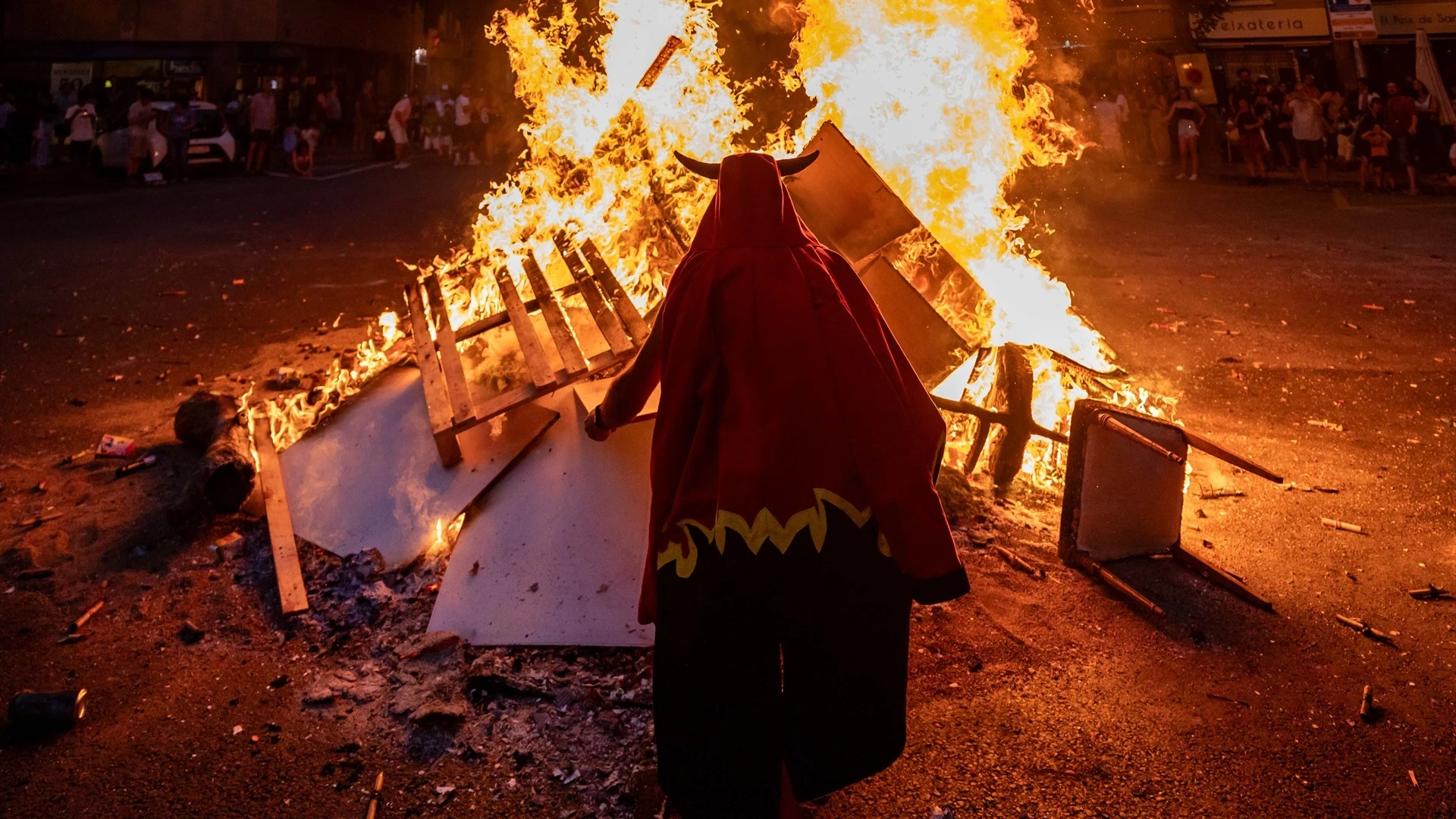 Uno de los Diablos de Sant Antoni frente a una hoguera en la noche de San Juan de Barcelona.