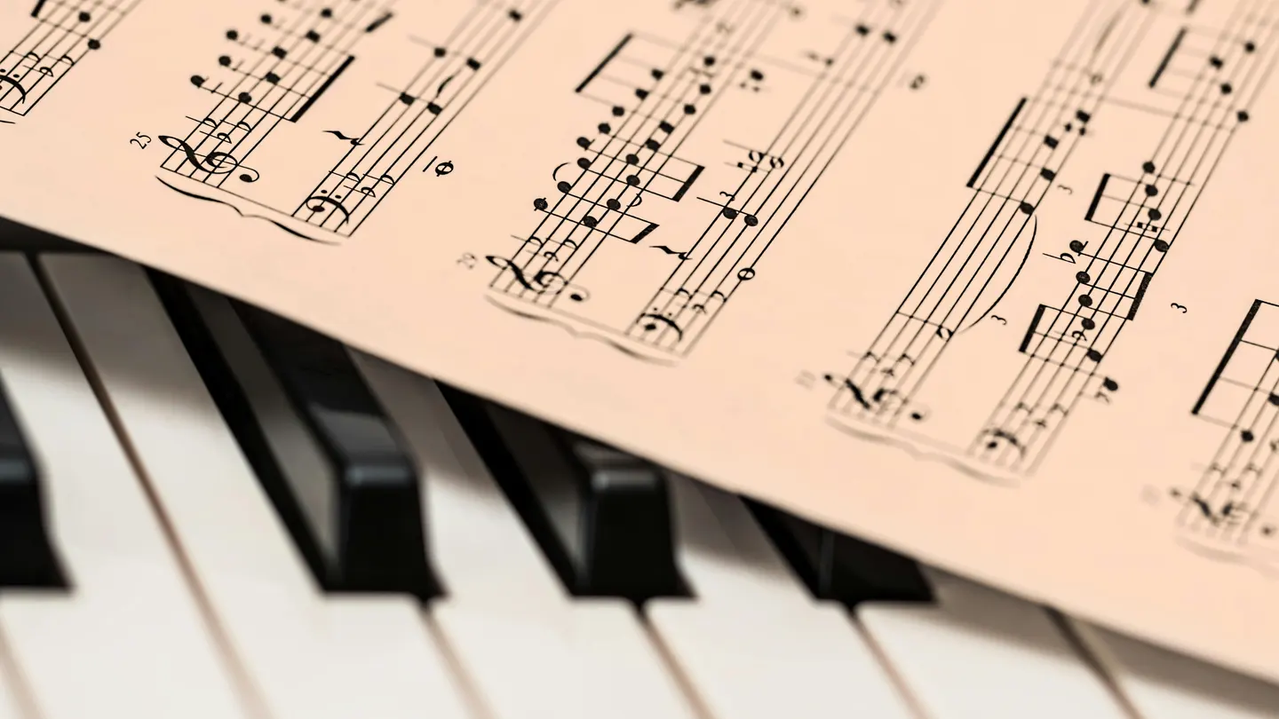 Una partitura de música sobre un piano Una partitura de música sobre un piano