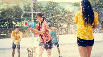 Gente joven jugando con pistolas de agua