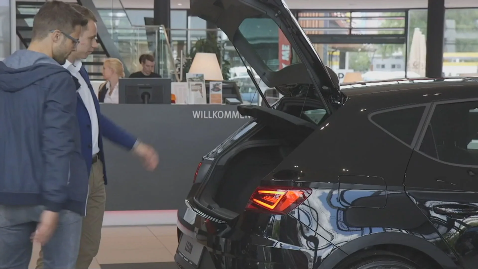 Dos hombres observan un coche Dos hombres observan un coche